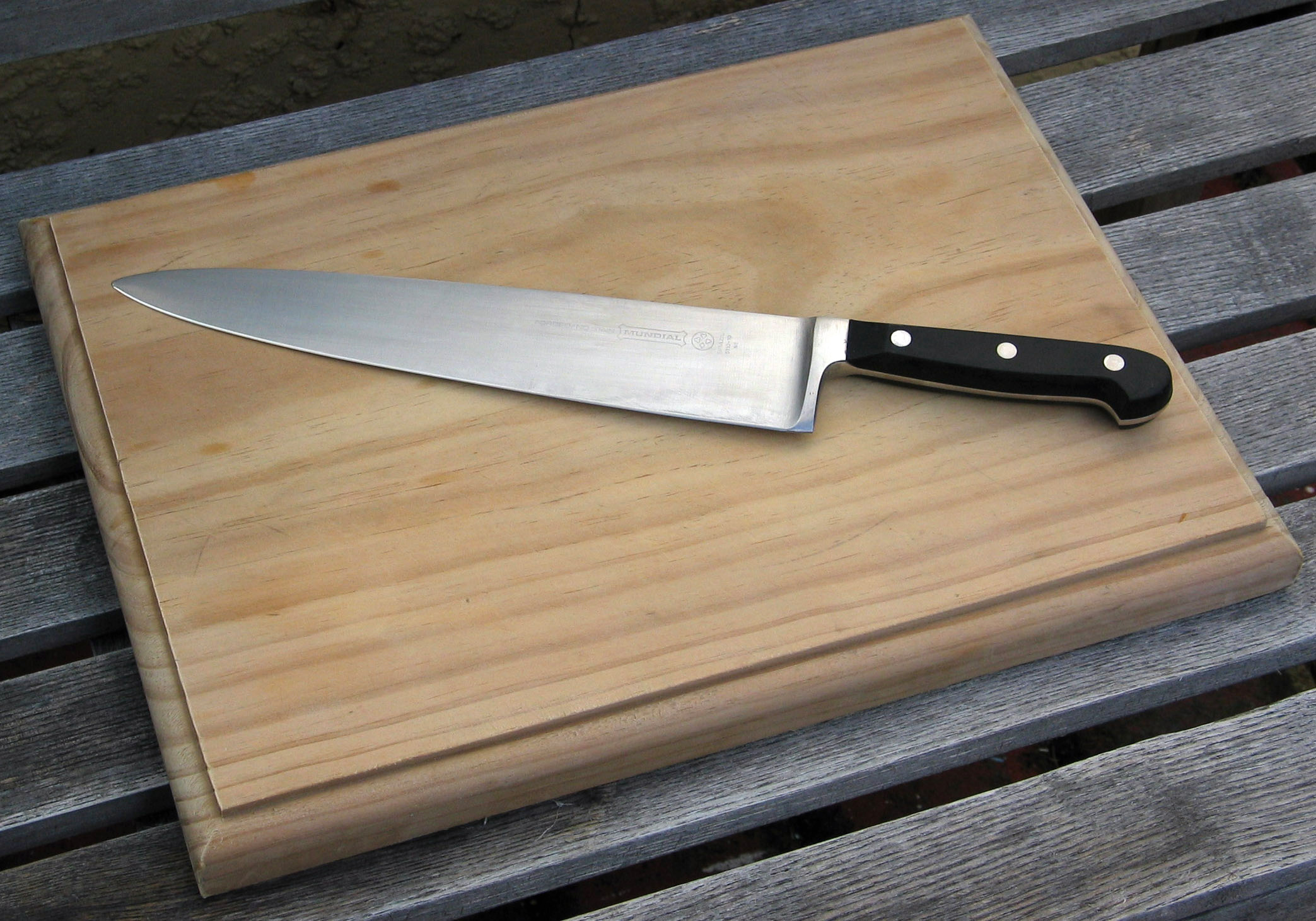 A knife on top of a cutting board.